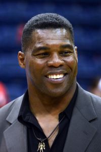 Potriate Photo of Herschel Walker wearing a dark grey coat with a black shirt. 